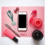 Pinkes Layflat mit Handy, Flamingo-Klebestreifen, Stiften und Kameraobjektiv